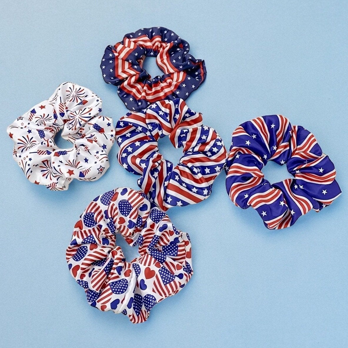 5 scrunchies in various 4th of July themed prints. All three consist of different styles of red, white and blue Independence Day themed patterns.