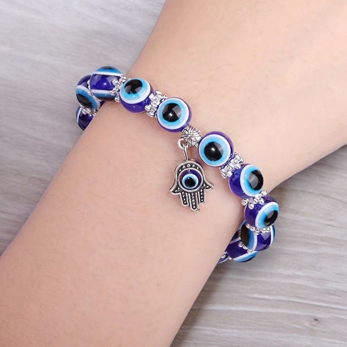 Blue evil eye Hamsa hand bracelet on a woman's wrist