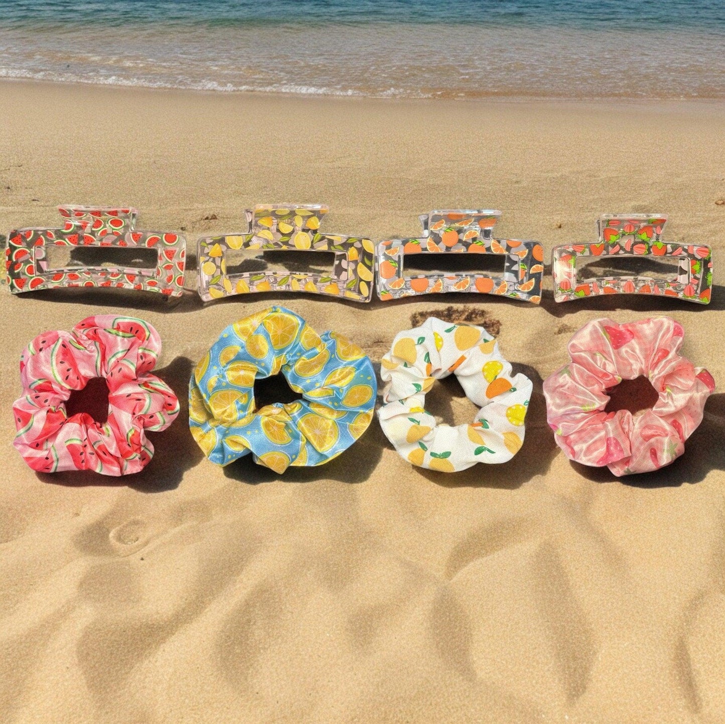 4 pairs of claw clips and scrunchies. One pair is a watermelon print hair claw and scrunchie, one pair is a lemon print hair claw and scrunchie, one is an orange print hair claw and scrunchie, and the last is a strawberry print claw and scrunchie.