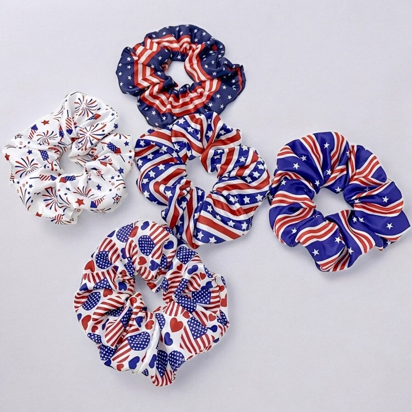 5 4th of July American themed scrunchies laying on top of a white background.